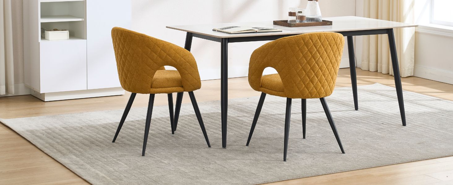Ensemble de salle à manger moderne avec deux chaises matelassées jaune moutarde et une table à manger encadrée en noir sur un tapis beige.