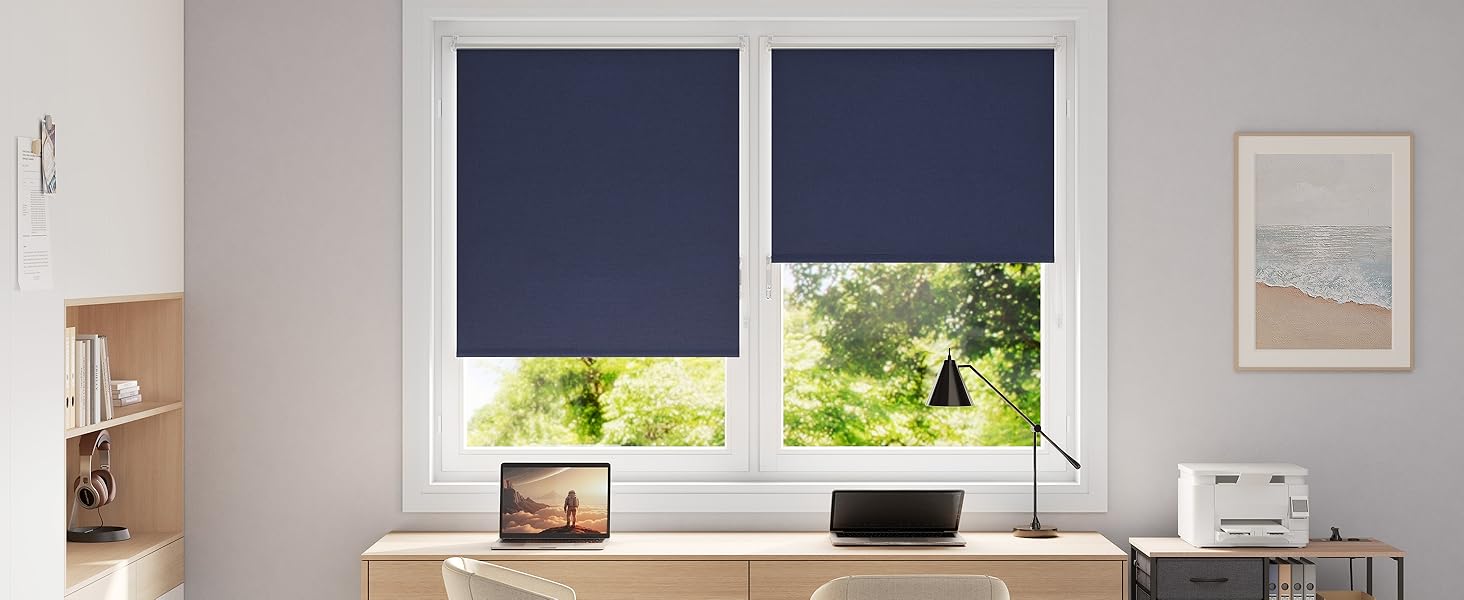 Repetición de la imagen de la oficina en casa con persianas enrollables de color azul marino en las ventanas, el escritorio de madera y las computadoras portátiles, que se muestran desde un ángulo ligeramente diferente.