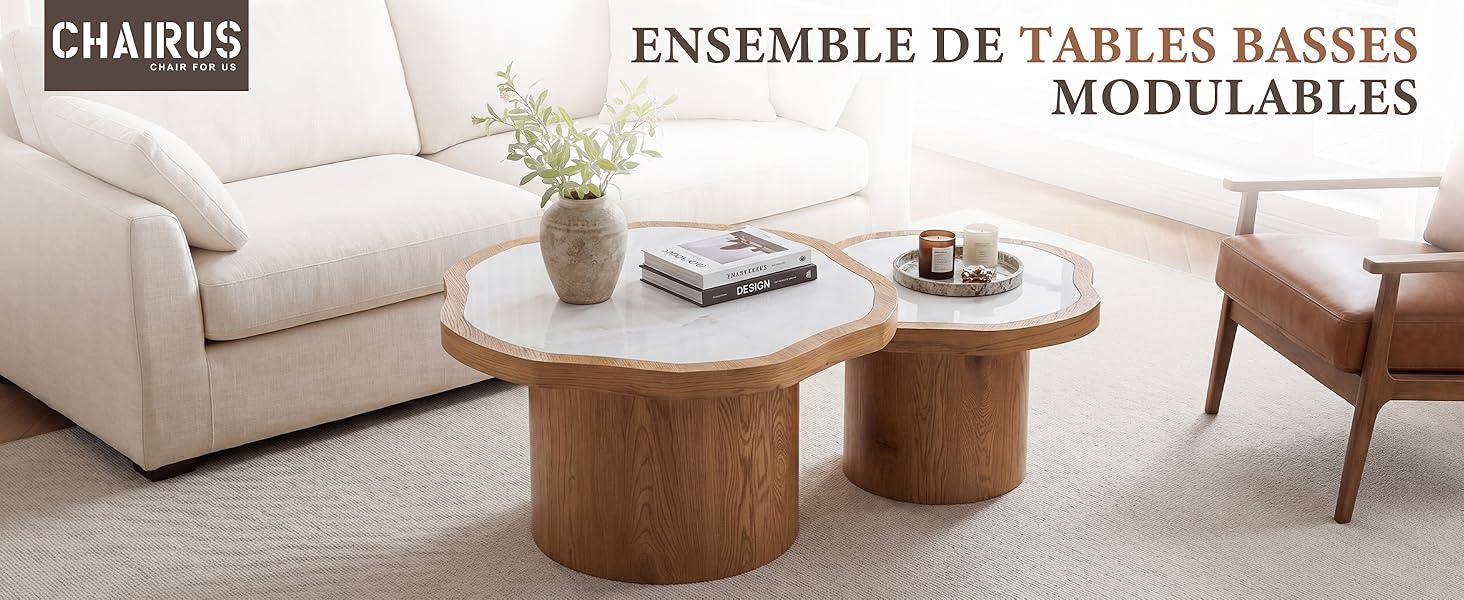 Le texte se lit comme suit : « CHARUS » et « ENSEMBLE DE TABLES BASSES MODULABLES ». Ensemble de table basse modulaire beige avec table d'appoint ronde en bois, canapé crème et accessoires exposés dans le salon.