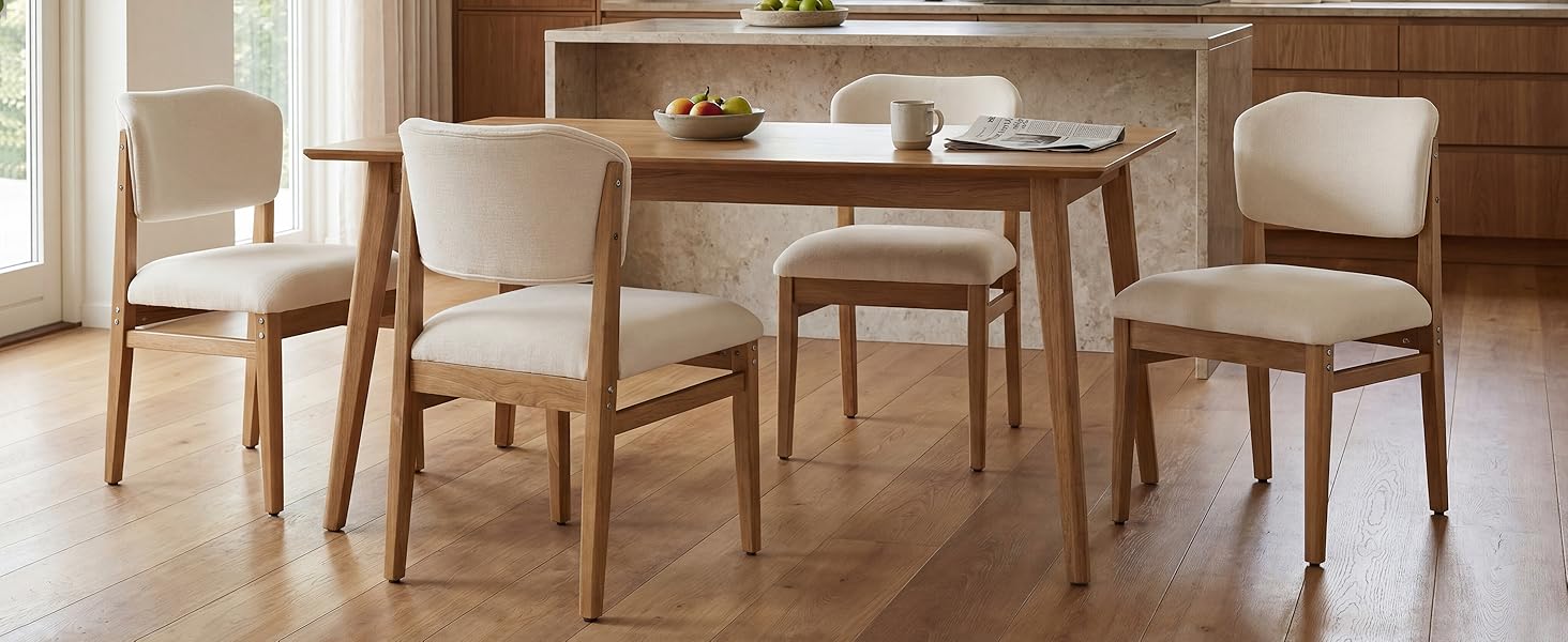 Ensemble de salle à manger en bois avec table au fini naturel et quatre chaises rembourrées de couleur crème avec pieds en bois sur parquet.