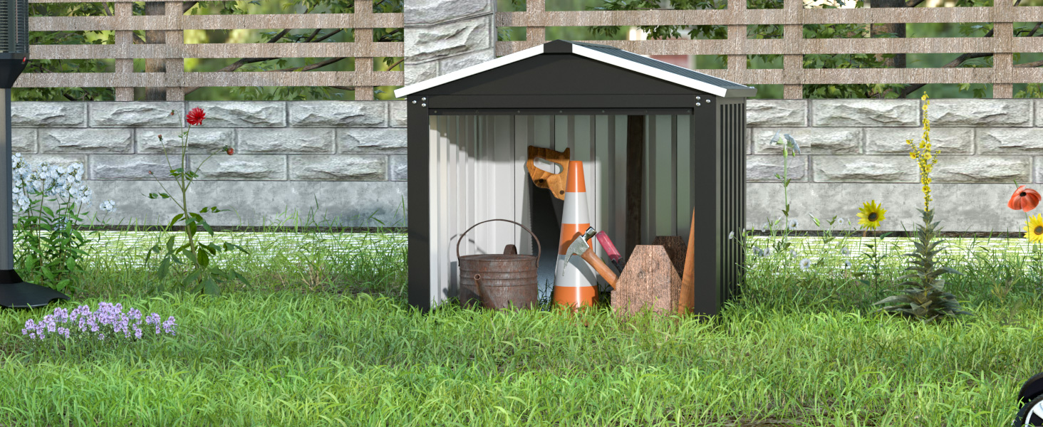 Petit abri de jardin en métal dans une cour gazonnée. La porte ouverte révèle les outils de jardinage à l'intérieur. Une clôture en bois est visible en arrière-plan.