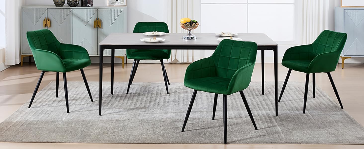 con mesa rectangular blanca y cuatro sillas de terciopelo verde esmeralda. Colóquelo sobre una alfombra luminosa en una habitación luminosa y minimalista.