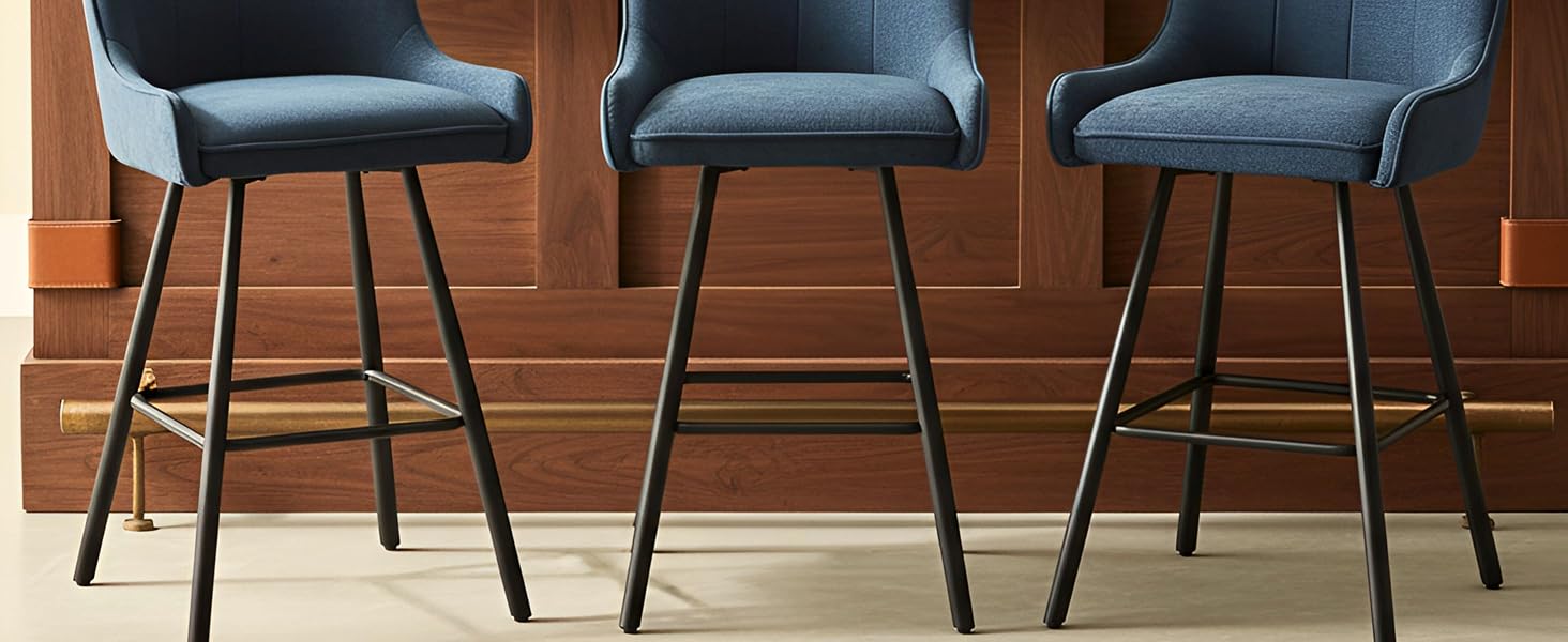Trois tabourets de bar modernes avec sièges et dossiers rembourrés gris, dotés de structures en métal noir, disposés en rangée contre des lambris en bois.