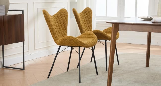 Moderna decoración de comedor con sillas tapizadas de color amarillo mostaza con patas de metal negro, dispuestas alrededor de una mesa de comedor de madera.