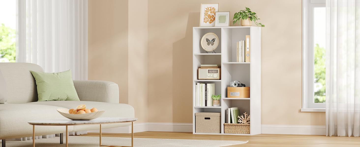 una estantería blanca con libros y una planta.