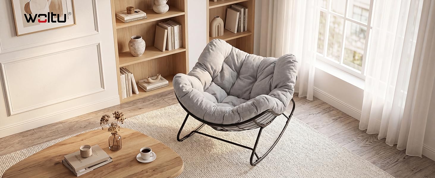 Le texte indique « veífu ». Chaise papasan grise matelassée avec structure en métal près de la fenêtre dans une chambre lumineuse et minimaliste avec armoire blanche et parquet visible.