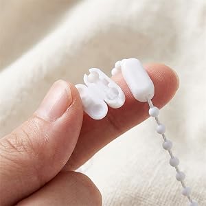 Close-up shots of small white spherical or round objects being handled or displayed on a light-colored surface.