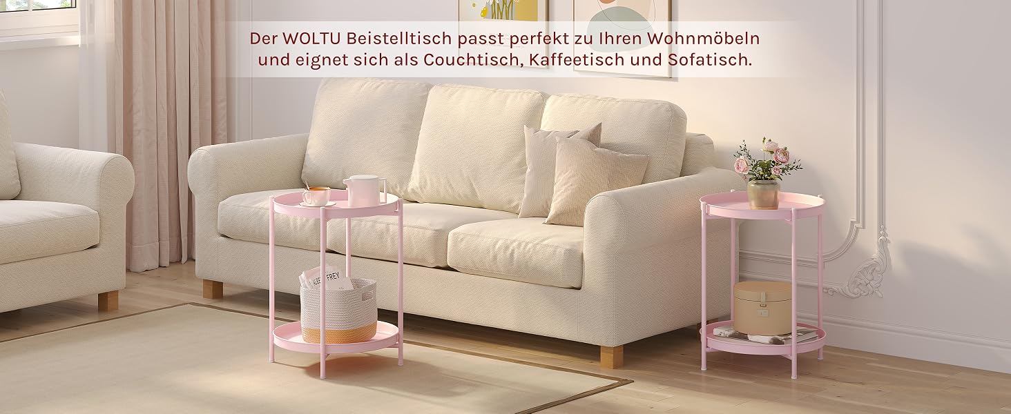 Wohnzimmer mit cremefarbener Couch, Sesseln und rosafarbenen Beistelltischen. Gemütlicher Raum mit Vorhängen und dekorativen Elementen, die eine warme Atmosphäre schaffen