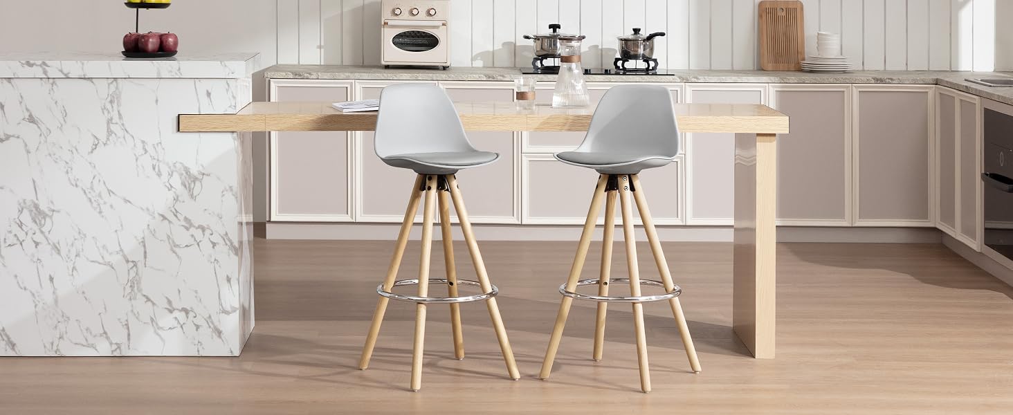 Isla de cocina moderna con encimera de mármol y voladizo de madera. Dos taburetes de bar acolchados de color gris con patas de madera. Suelos de madera clara y gabinetes blancos