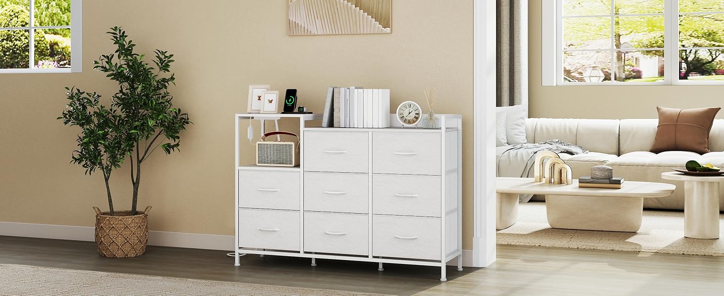 Arrangement moderne de meubles de rangement blancs contre des murs clairs, comprenant de multiples armoires et des plantes décoratives dans un cadre intérieur minimaliste.