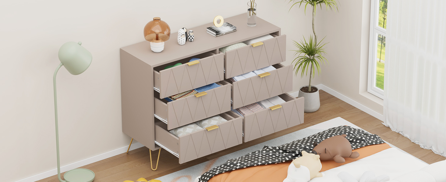 Comò moderno di colore chiaro con sei cassetti su due file, in stile minimalista con piante decorative e tappeto a motivi geometrici.