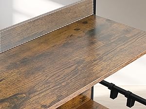 Primo piano della superficie di un tavolo o di uno scaffale in legno con una finitura macchiata scura, che mostra la trama delle venature e l'hardware di montaggio lungo