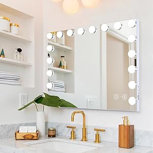 avec ampoules LED au-dessus d'un lavabo de salle de bain. Robinet doré visible. Étagère blanche avec objets décoratifs sur la gauche. Accessoires pour plantes et bois sur le plan