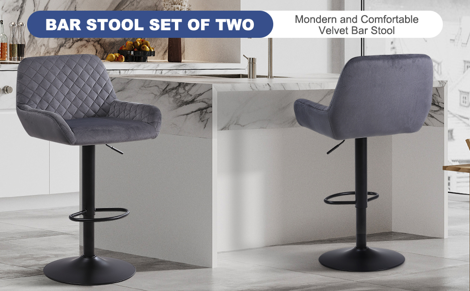 Set of two modern quilted velvet bar stools in gray with curved backs, padded seats, and black metal bases with footrests.
