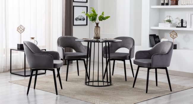 Modern dining set with round black table and four gray upholstered chairs. Sleek design features metal legs and curved chair backs, suitable for contemporary interiors.