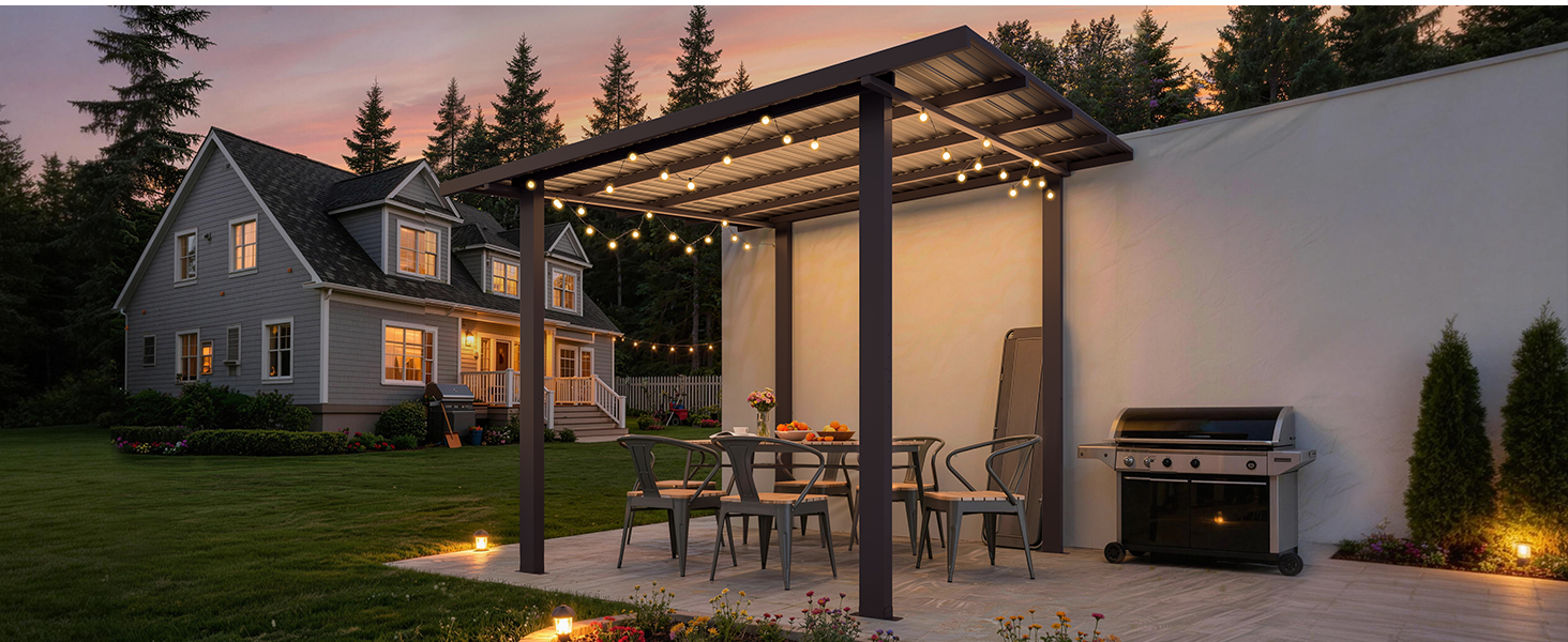 Modern house with illuminated exterior at dusk, featuring pergola with integrated lighting, patio seating area, landscaping, and adjacent deck with grill.