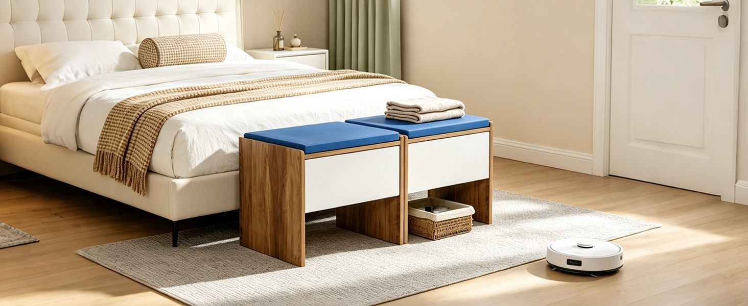 Panca portaoggetti imbottita blu con gambe in legno posizionate ai piedi del letto beige in una camera da letto neutra con pareti bianche e pavimento in legno chiaro.