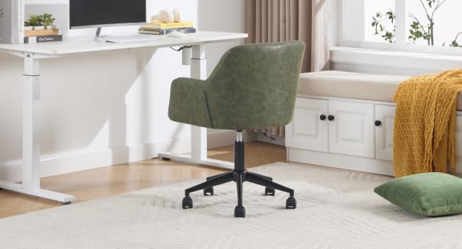 Configurazione per l'home office con scrivania bianca regolabile in altezza, sedia da ufficio imbottita verde su ruote e arte decorativa da parete. Coperta gialla visibile nell'angolo.