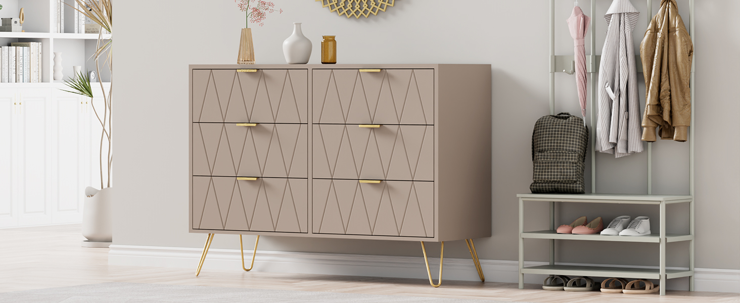 L'intérieur moderne comprend un buffet gris à motif géométrique et des pieds dorés, associé à un meuble de rangement blanc contre un mur blanc.