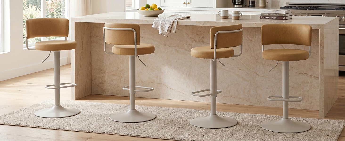 Interno moderno con quattro sgabelli da bar regolabili color marrone/caramello con basi in metallo posizionate su un bancone in legno naturale. Scaffali in legno chiaro e pareti bianche visibili in una cucina pulita e contemporanea.