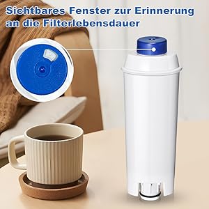Weiße zylindrische Wasserfilterpatrone mit blauer Kappe.
[SENTENCE 3] Verfügt über ein sichtbares Erinnerungsfenster.
[SENTENCE 4] Kaffeetasse und Untertasse im Vordergrund auf Holzoberfläche