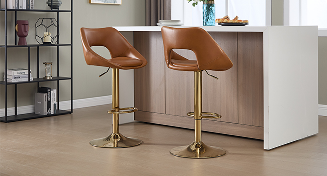 L'intérieur de la cuisine moderne comprend des tabourets de bar en cuir brun avec des bases dorées, un îlot de cuisine blanc et des étagères de style industriel.