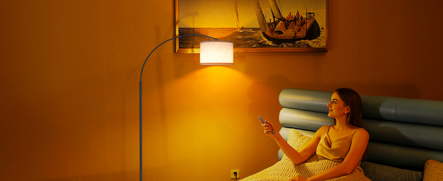 Person, die sich auf einer Couch entspannt und ein Tablet-Gerät unter warmem Licht einer Stehlampe in der Nähe benutzt. Wandkunst im Hintergrund sichtbar.