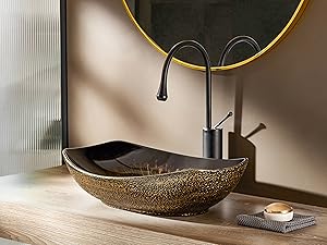 Lavabo de baño de lujo con cuenco de vaso de bronce texturizado y grifo negro mate, junto a un espejo redondo con marco dorado.
