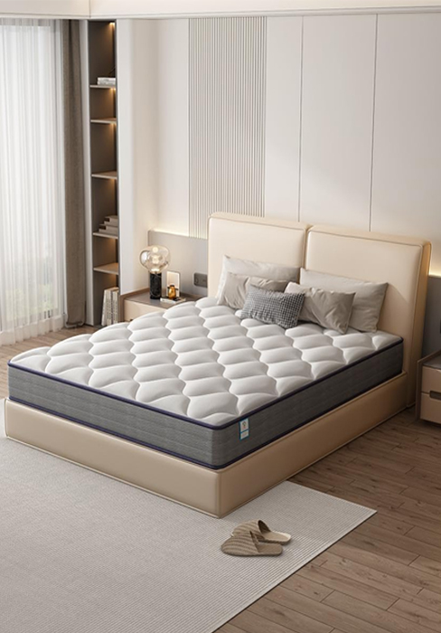 Aménagement de chambre moderne avec un matelas matelassé avec bordure grise sur un cadre de lit rembourré beige. Des rangements intégrés blancs et un parquet en bois clair complètent le design minimaliste.