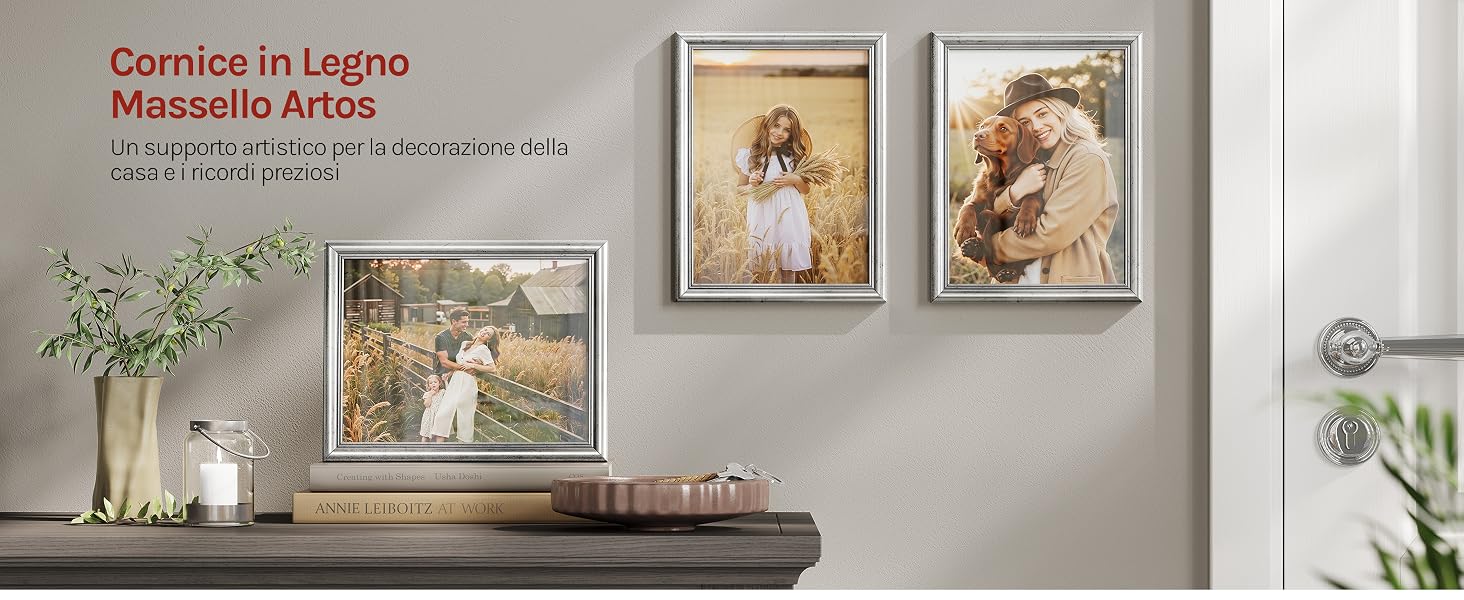 Il testo recita «Curated Living. Mosaïelle Atelier.» Espositore da parete per interni con opere d'arte incorniciate ed elementi decorativi tra cui vasi e oggetti di arredamento su una parete di colore chiaro.