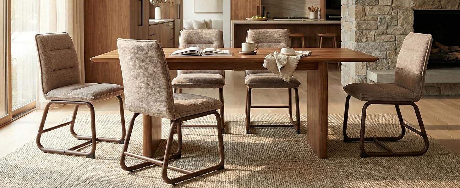 Modern dining set with wooden table and four upholstered chairs featuring metal cantilever bases. Room has stone accent wall and built-in shelving.