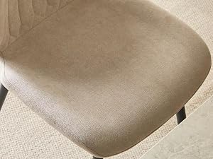 Gros plan de la surface d'un tissu beige ou crème avec une texture textile tissée douce et des détails de coutures visibles.