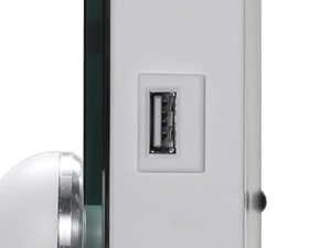 Close-up of a white wall-mounted USB port. Rectangular shape with metal trim, positioned next to a door handle or lock mechanism.