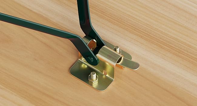 Schwarzer Gürtel mit goldfarbener Schnalle, der um das Holzmöbelbein auf hellem Holzboden befestigt ist und den Mechanismus und das Material des Gürtelverschlusses demonstriert.