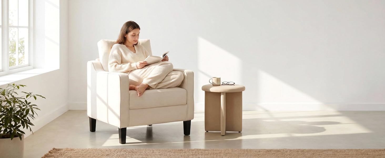 Light-filled interior scene featuring beige armchair with wooden side table and potted plant, demonstrating modern home furniture arrangement and natural lighting.