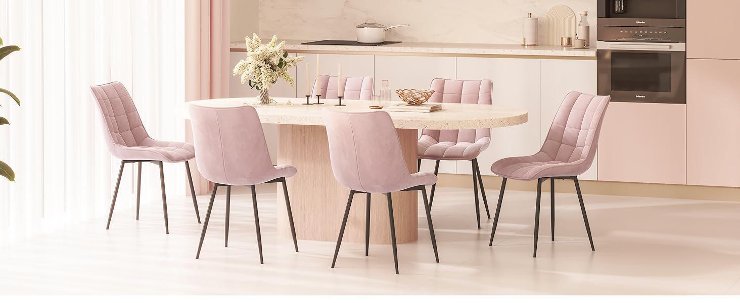 una sala da pranzo rosa con tavolo e sedie in marmo.