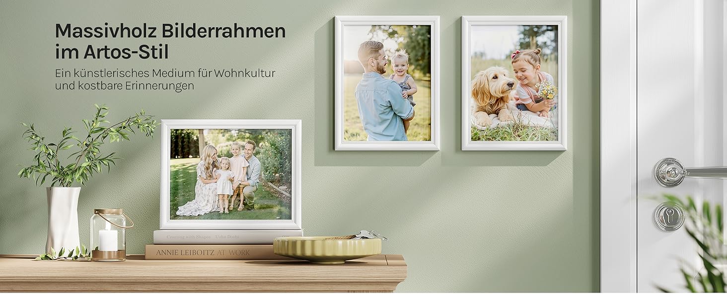 Der Text lautet: 'Messerholz Bilderrahmen'. Galerie-Wanddisplay mit mehreren gerahmten Bildern, die auf einer hellgrünen Wand angeordnet sind.