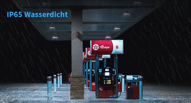 Tankstelle mit roten Kraftstoffpumpen bei Regen. Auf der Texteinblendung steht „IP65 Wasserdicht“ (IP65 Waterproof), was die Wasserdichtigkeit angibt