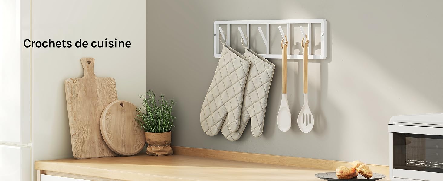 Le texte se lit comme suit : « Crochets de cuisine ». Étagère murale en bois avec sets de table ronds tissés, torchons de cuisine roulés et crochets à ustensiles présentant des articles de rangement culinaires.