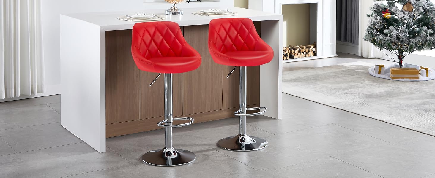 Dos taburetes de bar ajustables acolchados rojos con bases cromadas, colocados en una isla de cocina blanca. Decoración navideña visible en segundo plano