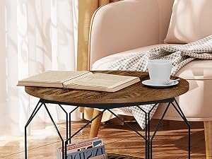 Round wooden coffee table with metal frame legs, styled with open book and white coffee cup, showcasing modern industrial design.