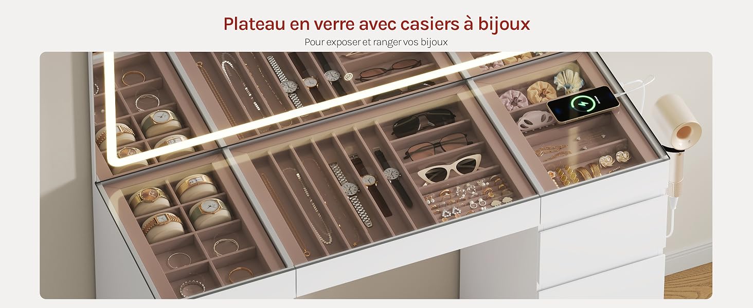 Le texte se lit comme suit : « Plateau en verre avec coussin à bijoux ». Présentoir à bijoux en verre avec plusieurs compartiments, rangement organisé pour les bagues et les accessoires, présenté dans un tiroir en bois clair.