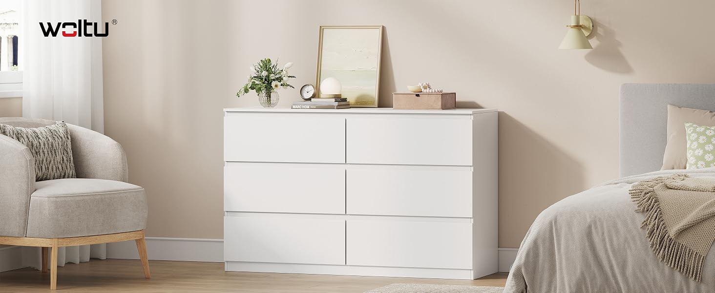 Le texte indique « UNIQUEMENT ». Intérieur de chambre moderne et minimaliste comprenant une commode blanche, un fauteuil aux tons neutres et des éléments de décoration coordonnés.