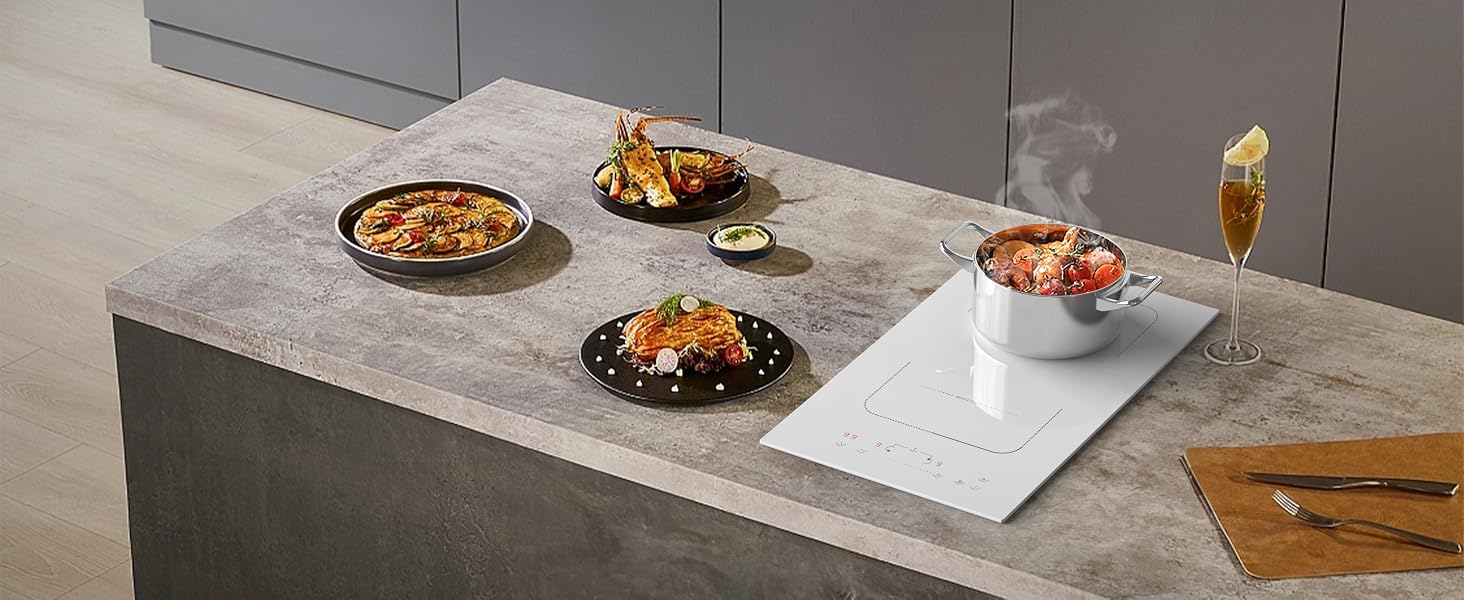 Configuration de salle à manger moderne sur une surface en béton avec plusieurs assiettes sombres avec des plats préparés, un bol blanc et un verre à pied sur fond gris