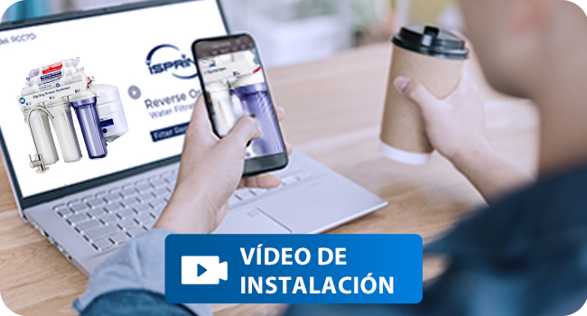 Interfaz de video de instalación que muestra el diagrama del sistema de filtración de agua en la pantalla del portátil, con el teléfono móvil y los componentes del producto visibles.