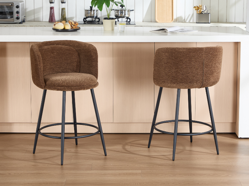 Braune gepolsterte Esszimmerstühle mit schwarzen Metallbeinen, dargestellt in einer modernen Kücheneinrichtung mit Holzboden und weißen Arbeitsplatten.