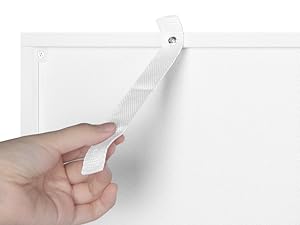 a hand holding a white paper hanging on a white wall.