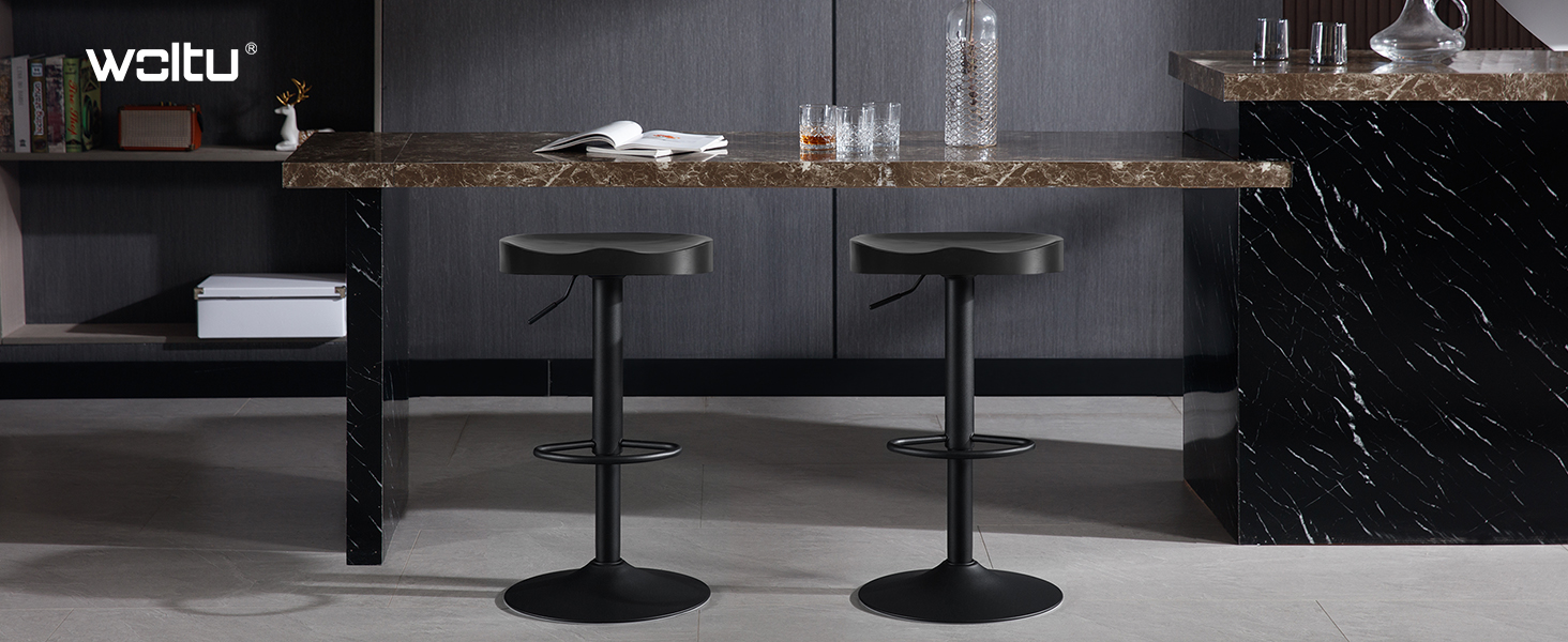 Dos taburetes de bar ajustables negros con asientos y reposapiés redondos, colocados en una isla de cocina con cubierta de mármol en una cocina moderna