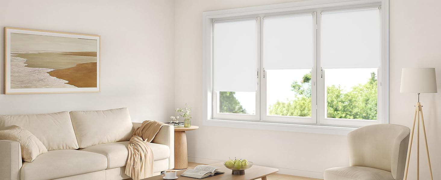 Vistas interiores de una sala de estar moderna con muebles blancos, que muestran la luz natural que se filtra a través de los tratamientos de las ventanas.