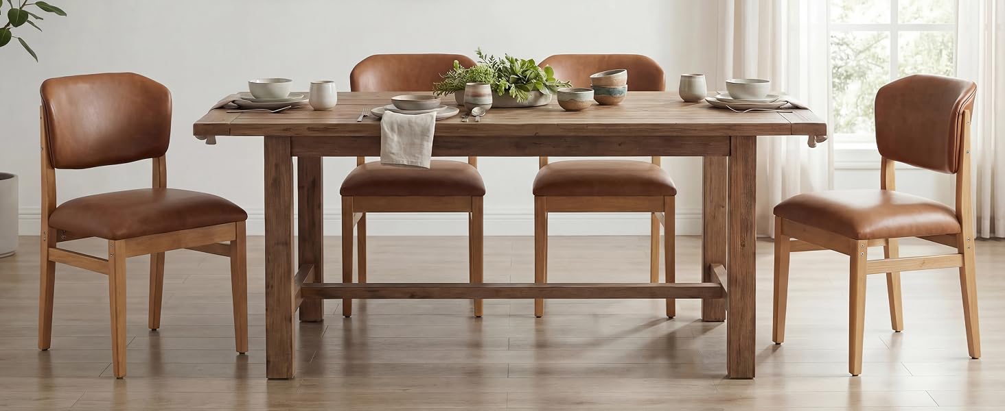 Ensemble de table à manger en bois avec quatre chaises en cuir marron dans un espace intérieur lumineux et minimaliste avec des plantes en pot et une lumière naturelle provenant de la fenêtre.
